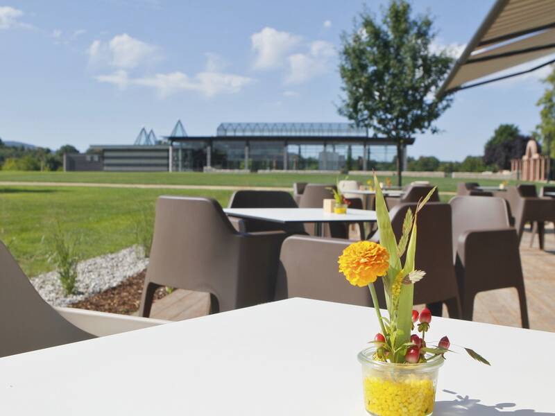 Die Tische auf der Terasse vom Café artis, mit Blick Richtung Villa urbana.