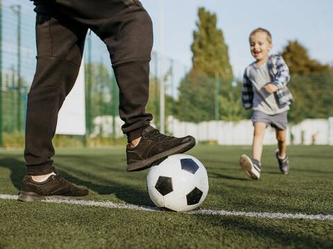 Vater und Sohn beim Fußballspielen.